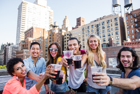 Group of friends spending time together on a rooftop in New york city, lifestyle concept with happy peopleの写真素材