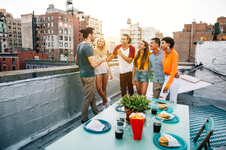Group of friends spending time together on a rooftop in New york city, lifestyle concept with happy peopleの写真素材