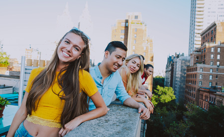 Group of friends spending time together on a rooftop in New york city, lifestyle concept with happy peopleの写真素材