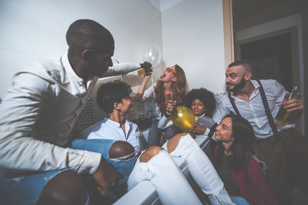 A group of young people celebrating and making party at homeの写真素材