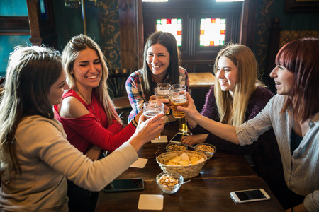 Group of happy friends having party in a bar  - Young people drinking beerの写真素材