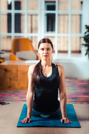 Athletic beautiful woman training at home - Young girl doing fitness in her apartment, concepts about fitness, sport and healthの写真素材