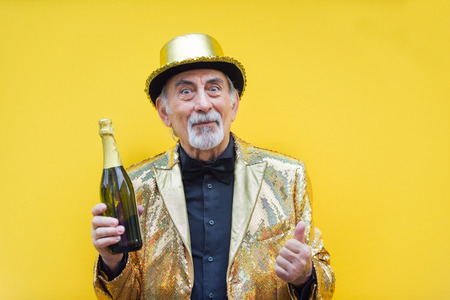 Funny and extravagant senior man posing on colored background - Youthful old man in the sixties...
