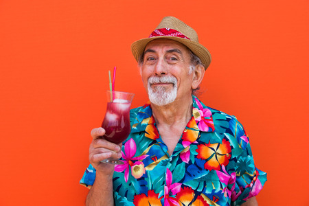 Funny and extravagant senior man posing on colored background - Youthful old man in the sixties having fun and partyingの写真素材
