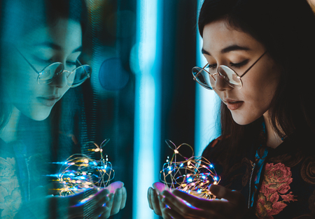 Beautiful mixed race woman posing outdoors, background with blurred neon lights