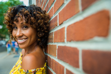 Happy african american woman smiling. Beautiful young female walking and having fun in New York cityの写真素材