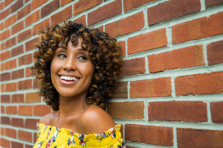 Happy african american woman smiling. Beautiful young female walking and having fun in New York cityの写真素材