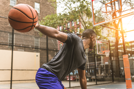 Afro-american basketball player training on a court in New York - Sportive man playing basket outdoorsの写真素材
