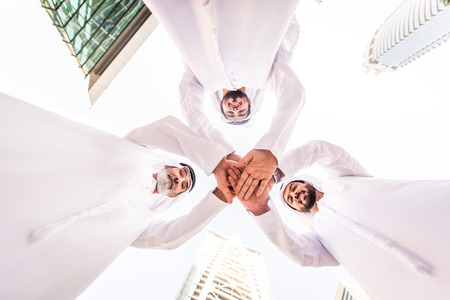Group of arabian businessmen with kandura meeting outdoors in UAE - Middle-eastern men in Dubaiの写真素材