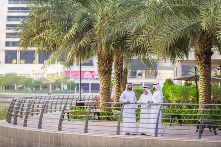 Group of arabian businessmen with kandura meeting outdoors in UAE - Middle-eastern men in Dubaiの写真素材