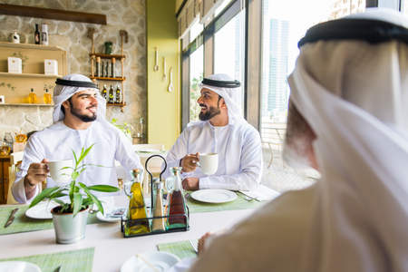 Group of middle eastern men wearing kandora bonding in a cafÃ¨ restaurant in Dubaiの写真素材
