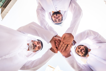 Group of arabian businessmen with kandura meeting outdoors in UAE - Middle-eastern men in Dubaiの写真素材