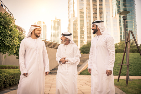 Group of arabian businessmen with kandura meeting outdoors in UAE - Middle-eastern men in Dubaiの写真素材