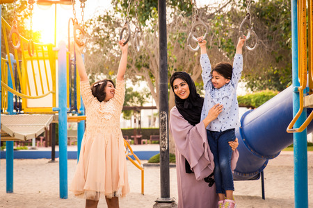 Happy arabian family having fun in Dubai - Mom together with her daughters in park play area
