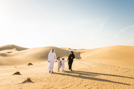 Arabian family with kids having fun in the desert - Parents and children celebrating holiday in the Dubai desrtの写真素材