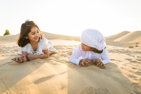 Arabian family with kids having fun in the desert - Parents and children celebrating holiday in the Dubai desrtの写真素材