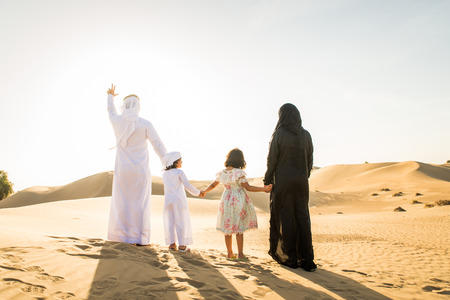 Arabian family with kids having fun in the desert - Parents and children celebrating holiday in the Dubai desrtの写真素材