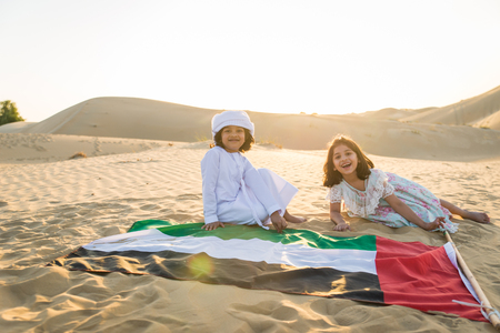 Arabian family with kids having fun in the desert - Parents and children celebrating holiday in the Dubai desertの写真素材
