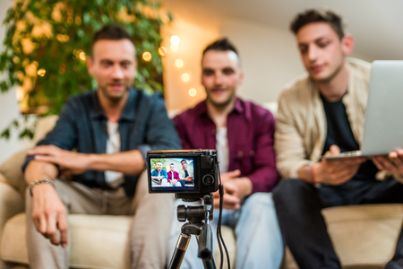 Group of social network influencers filming a vlog at home, talking and reviewing a product