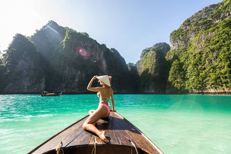 Beautiful woman on a long-tail boat in Phi Phi Island, Thailand - Young pretty girl on summer vacation in south-eastern asiaの写真素材