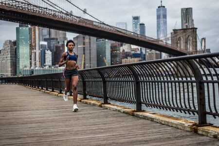 Young fitness woman running in New York - Sportive girl training outdoors, concepts about sport and healthy lifestyleの写真素材