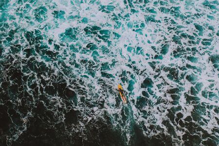 Aerial shot of surfers doing surf at sunset time. picture provided with drone. Concept about nature...