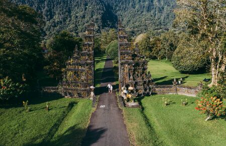 Happy couple spending time at the handara's gate in bali. walking on the street to the historic doorの写真素材