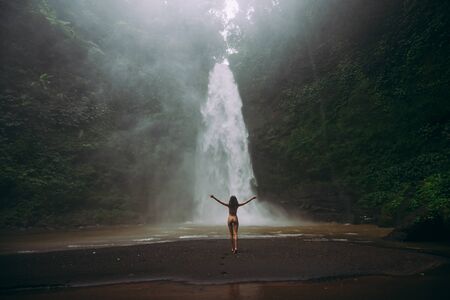 Beautiful girl having fun at the waterfalls in Bali. Concept about wanderlust traveling and wilderness cultureの写真素材