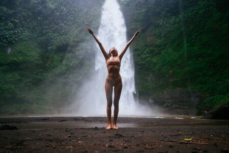 Beautiful girl having fun at the waterfalls in Bali. Concept about wanderlust traveling and wilderness cultureの写真素材