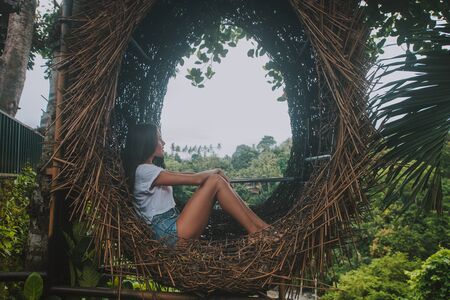 Beautiful girl having fun at the waterfalls in Bali. Concept about wanderlust traveling and...