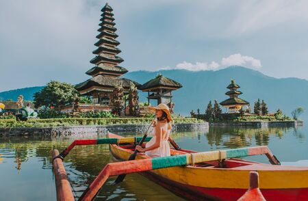 Beautiful girl kayaking on the catamaran at the ulun datu pura bratan temple, in Baliの写真素材