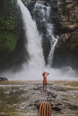 Beautiful girl having fun at the waterfalls in Bali. Concept about wanderlust traveling and wilderness cultureの写真素材