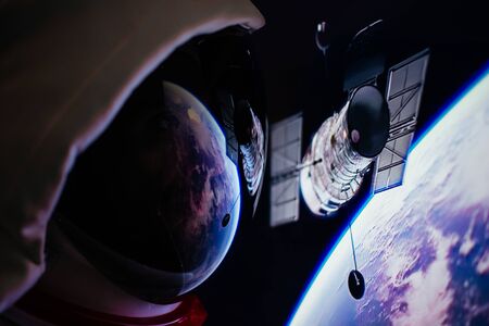 Astronaut looking deep space, galaxy and planets from the window of his capsule. Concept about science and space explorationの写真素材