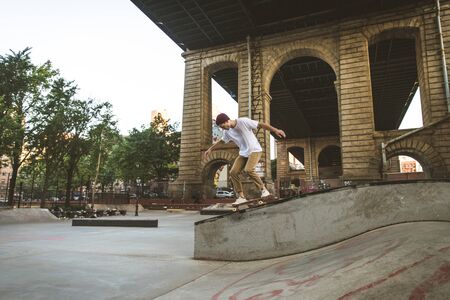 Young adult skating outdoors - Stylish skater boy training in a New York skate park, concepts about...