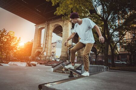 Young adult skating outdoors - Stylish skater boy training in a New York skate park, concepts about sport and lifestyleの写真素材