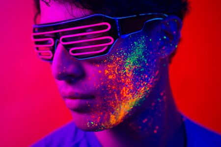 Portrait of fashionable man  with colored  painting on the faceの写真素材