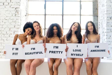 Multi-ethnic group of beautiful women posing in underwear in a beauty studioの写真素材