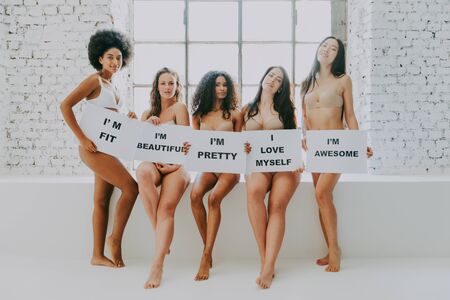 Multi-ethnic group of beautiful women posing in underwear in a beauty studioの写真素材