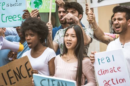 Group of activists is protesting outdoors - Crowd demonstrating against global warming and plastic pollution, concepts about green ecology and environmental sustainabilityの写真素材