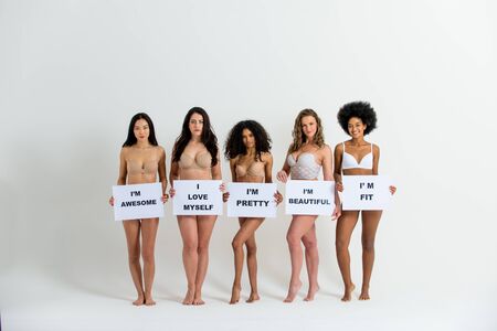 Multi-ethnic group of beautiful women posing in underwear in a beauty studioの写真素材