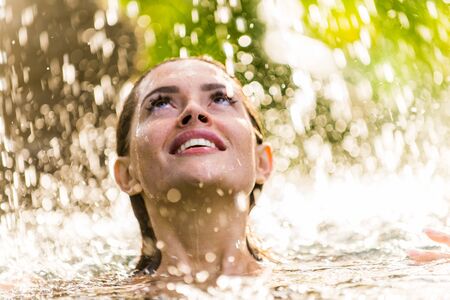 Beautiful woman in bikini relaxing in a outdoor swimming pool in a Bali luxury resort