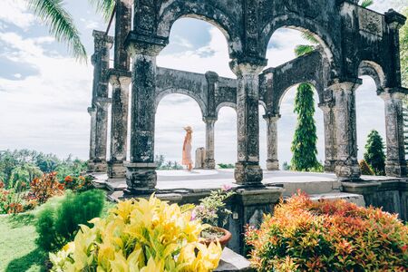 Young beautiful woman in Taman Ujung water palace, Bali island, Indonesiaの写真素材