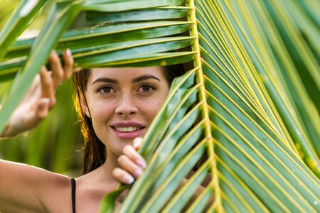 Beautiful woman in bikini relaxing in a outdoor swimming pool in a Bali luxury resortの写真素材