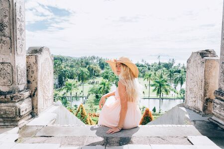 Young beautiful woman in Taman Ujung water palace, Bali island, Indonesiaの写真素材