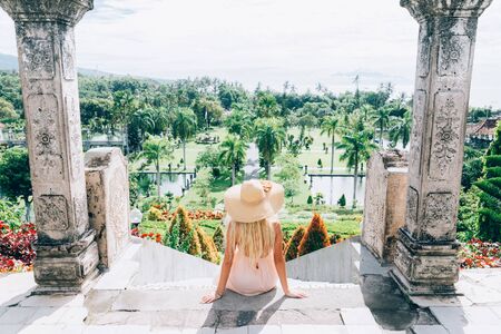 Young beautiful woman in Taman Ujung water palace, Bali island, Indonesiaの写真素材