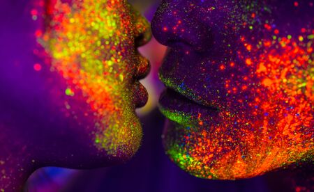 Portrait of fashionable couple  with colored  painting on the faceの写真素材