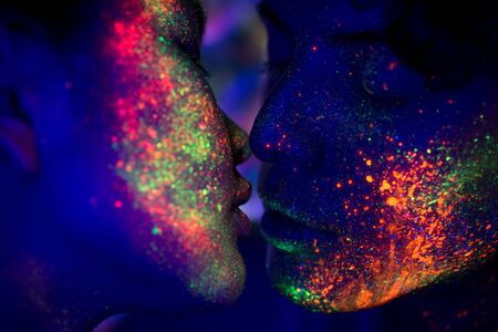 Portrait of fashionable couple  with colored  painting on the faceの写真素材