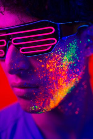 Portrait of fashionable man with colored  painting on the faceの写真素材