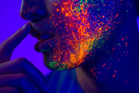 Portrait of fashionable man with colored  painting on the faceの写真素材