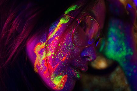 Portrait of fashionable woman with colored fluo painting on the face - Fashion model on colored backgroundの写真素材